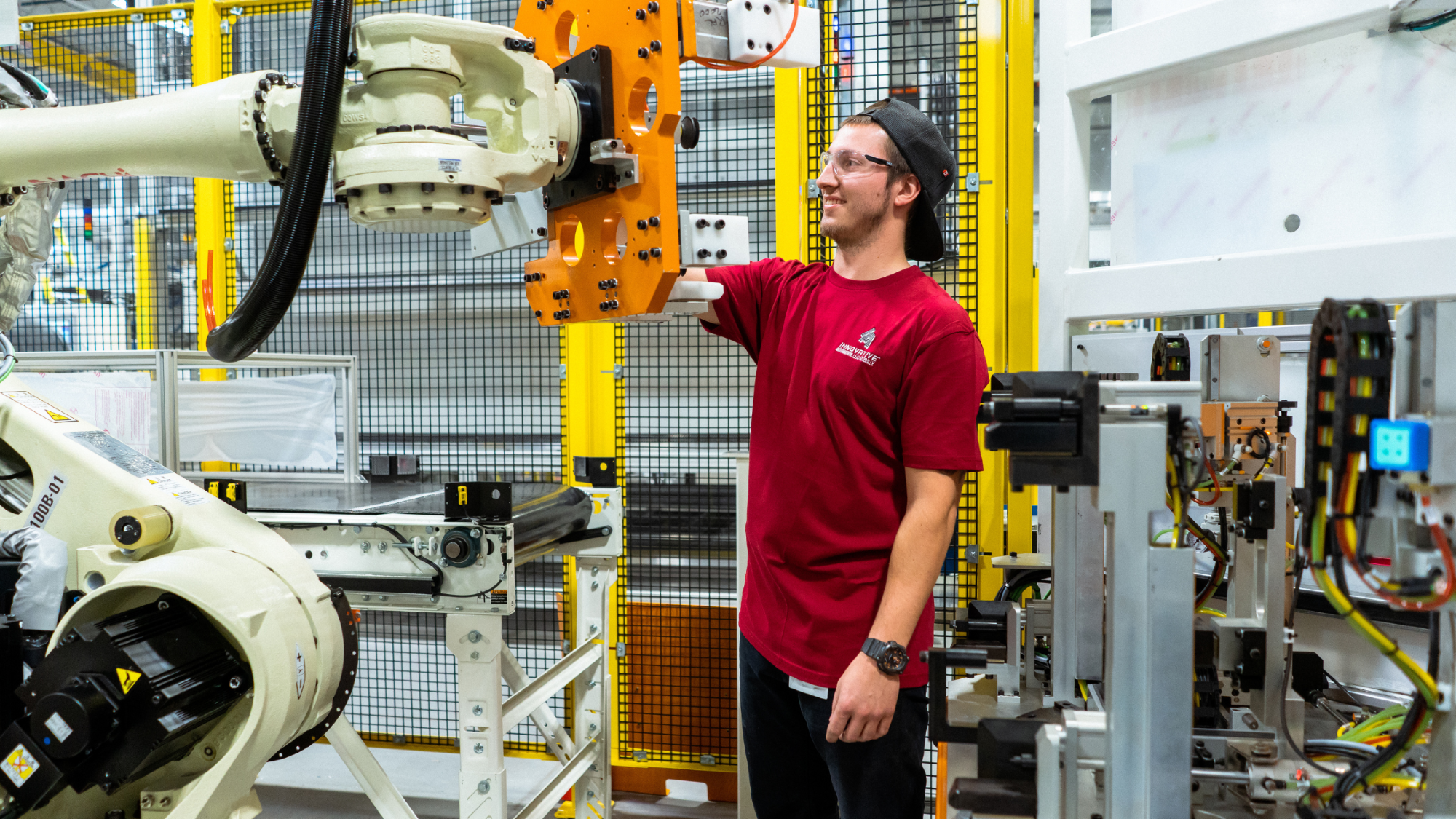 Innovative Automation engineer inspecting an industrial robotic arm during system integration at our Barrie, Ontario facility.
