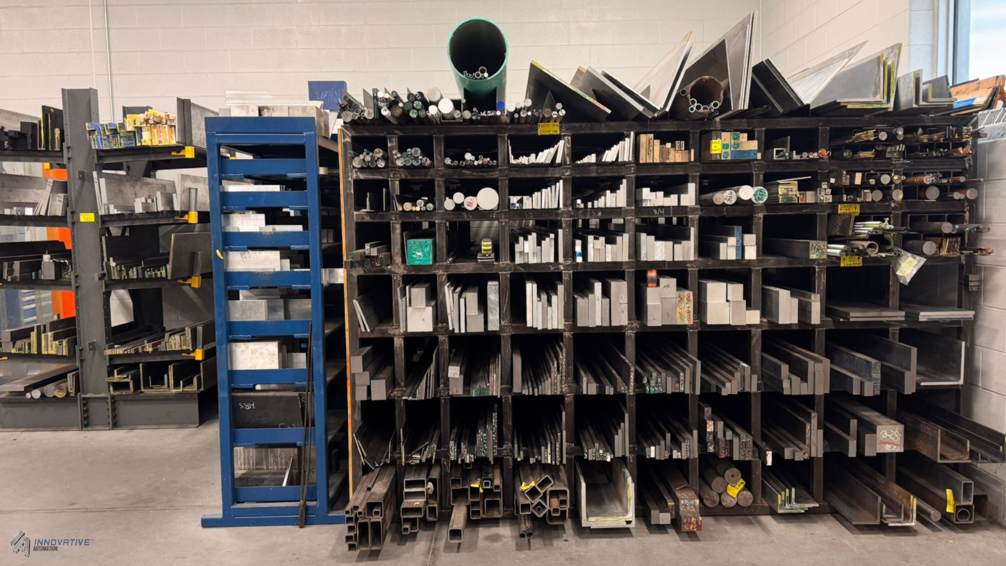Raw aluminum and steel stock organized in a machining shop at Innovative Automation facility in Barrie